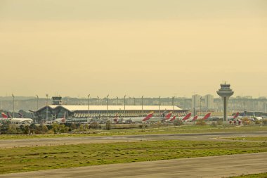 Madrid Barajas havaalanının kalkış pistlerinden birinin, bir terminalin ve kontrol kulesinin görüntüsü.