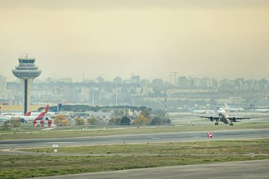 Kontrol kulesinin yakınından bir yolcu uçağı kalkıyor.