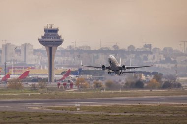 Türbinleri maksimum güçte olan bir yolcu uçağı Madrid Adolfo Suarez Barajas Havaalanı 'nın kontrol kulesi yakınlarında kalkış yapıyor.