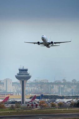 Madrid Barajas havaalanının kontrol kulesinin yakınından geçen bir uçak.