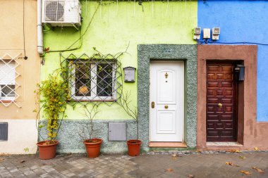 Kastilya ahşap kapıları ve beyaz zırhlı kapıları olan, iki katlı, tek aile evlerinin dekoratif yüzleri.