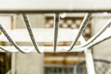 Yağmur suyu damlalarıyla dolu beyaz bir plastik raf.