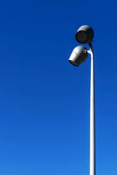 An urban lighting street lamp with two lamps and a deep blue sky