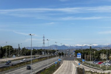 Madrid, İspanya 'daki Sierra de Navacerrada dağının karlı dağına giden birkaç şeritli bir yol.