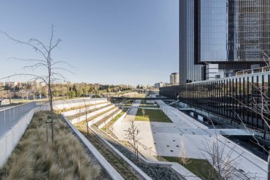 Madrid, İspanya 'nın kuzeyindeki ofis gökdelenlerinin yanında geniş merdivenleri olan ve bitkilerle dolu bir şehir eğlence parkı.