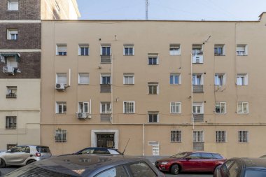 Kare pencereli bir apartmanın açık kahverengi cephesi