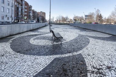 Siyah ve beyaz mermer parçalarıyla dolu katı zemini olan bir şehir yürüyüşü.