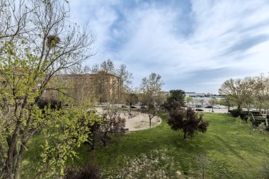 Bahçeli, çitli, çimenlikli ve ağaçlı büyük yeşil alanları olan konut binalarının cepheleri