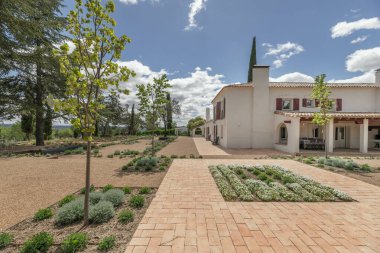 Newly planted gardens with terracotta and gravel floors in the patio of an Andalusian farmhouse style house clipart