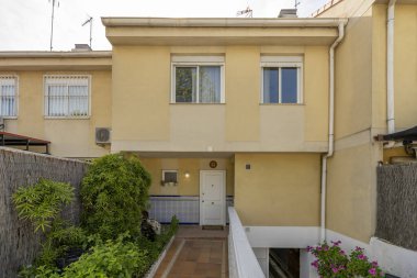 Yarı müstakil, terasotta zeminli, merdivenlerde beyaz beton balyoz ve birçok katı olan tek kişilik bir evin cephesi.