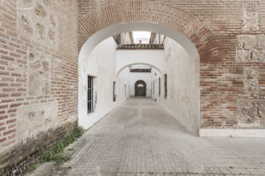 Tuğla cepheli anıtsal bir binanın duvarları beyazlatılmış bir koridor.