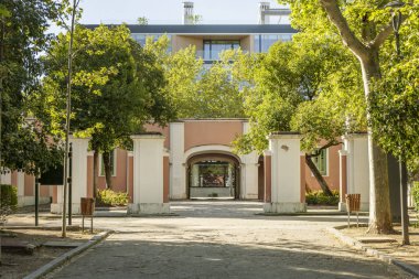 Bir sürü bitki örtüsü olan bir şehir parkına erişim sağlayan anıtsal taş girişte kum yürüyüşü.