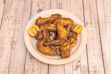 Barda tapa olarak servis edilen limonlu kızarmış tavuk kanadı.
