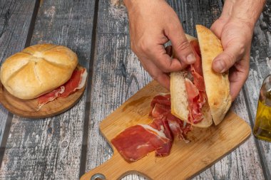 Lezzetli bir Serrano jambonlu sandviç, yağlı ve temiz elli iyi bir ekmek hazırlıyorum.
