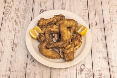 Barda tapa olarak servis edilen limonlu kızarmış tavuk kanadı.