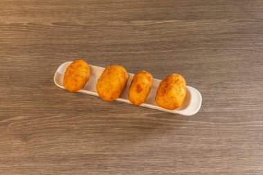 croquetes characterized by being small portions of dough that usually contain a filling, which can be meat, fish, seafood, vegetables or even cheese, and which are coated in breadcrumbs and fried until golden and crispy clipart