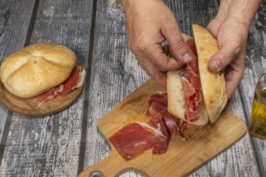 Lezzetli bir Serrano jambonlu sandviç, yağlı ve temiz elli iyi bir ekmek hazırlıyorum.
