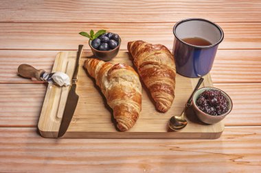 Kruvasanlar, un, tereyağı, su ve tuz karışımının mayalanması ve katlanmasıyla yapılan poğaça hamur işiyle yapılır..