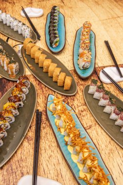 Bu lezzetli hazırlık, dıştaki pilav ve içerideki dolgu maddeleri ile karakterize edilir, geleneksel maki 'nin aksine, nori deniz yosunu dışarıda bulunur..