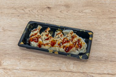 Japon gyozası genellikle daha ince bir hamura ve domuz eti, lahana, sarımsak ve zencefil gibi farklı bir dolguya sahiptir.