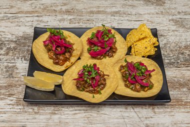 Tacos de Barbacoa *: Geleneksel olarak kuzu veya sığır etiyle yapılır, maguey yapraklarında buharla pişirilir.. 