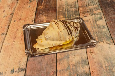 Beyaz çikolatayla kaplanmış tereyağlı kruvasan. Gümüş tepside taze pişmiş.