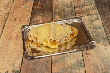 Beyaz çikolatayla kaplı tereyağlı kruvasan, gümüş tepside yeni pişmiş.