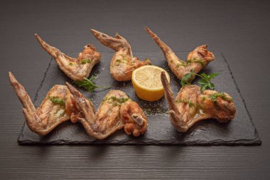 Tipik bir İspanyol tapası. Kızarmış tavuk kanadı ve garnitür olarak limon dilimleri.