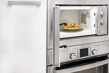 Mutfak gereçlerinde mikrodalganın içinde bir tabak cips.