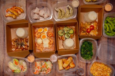 Tipik Asya yemekleri, taze pişmiş ve eve servis için plastik ve kartonla paketlenmiş.