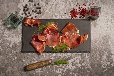 Siyah bir tepside tipik bir Serrano jambonu tapası.