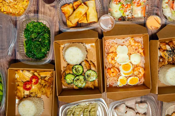 Tipik Asya yemekleri, taze pişmiş ve plastik ve kartonla paketlenmiş. Yukardan eve servis için.