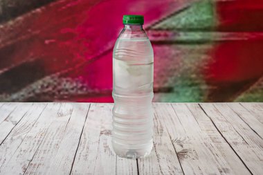 Beyaz bir masada berrak bir plastik su şişesi.