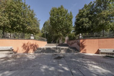 Kırmızı tuğla duvarlar arasındaki taş merdivenler. 