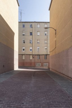 Kalitesiz konut binalarının birkaç cephesi arasındaki yaya geçidi.