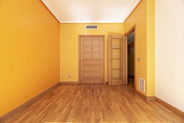 Mutfağa servis kapısı olan boş bir oturma odası ve havalandırma üniteleri.