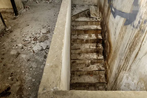 Aşağıda enkaz ve kirle dolu harabe bir binada.