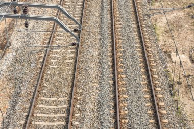 Rayların temeli, trenin yükünü daha geniş bir yüzeye dağıtan ezilmiş bir taş katmanıdır., 