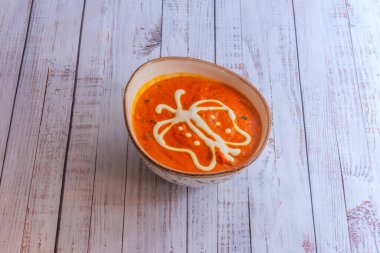 Kuzu, baharat açısından zengin, koyu kırmızı bir sosta pişmiş.,