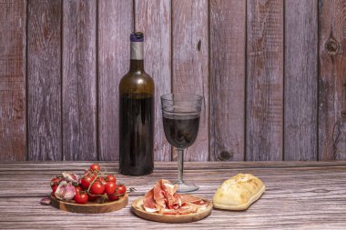 Ilık ışıkta parlayan yağ damarlarıyla meşe palamudu ile beslenmiş İber jambonu tahtasının yanında bir bardak tam vücut kırmızı şarap.
