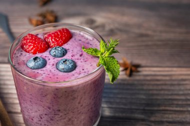 Taze meyve suyunu bardağa doldurup, taze bir dokunuş için etrafını kızılcık ve nane yapraklarıyla çevreleyin.