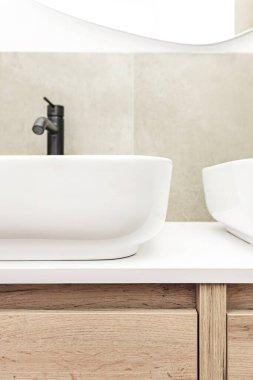 Çağdaş banyo dikdörtgen porselen lavabo, krom duvarlı mikser ve köşe duş muhafazası.