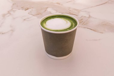 Yoğun zümrüt yeşil kibrit çayı kremalı süt ve buzla harmanlanmış baştan çıkarıcı yeşil köpükle kaplanmış.