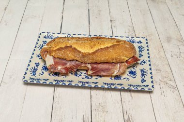 Kızarmış köy ekmeğinin arasında% 100 İber jambonlu kaliteli İspanyol sandviçi, mükemmel yağ bilyesini gösteriyor.