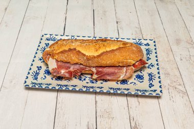 Kızarmış köy ekmeğinin arasında% 100 İber jambonlu kaliteli İspanyol sandviçi, mükemmel yağ bilyesini gösteriyor.