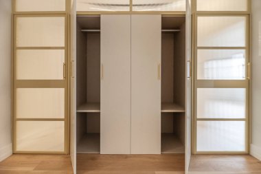 Paslanmaz çelik çerçeveli ve şeffaf cam panelli ağır beyaz gardırop kapıları.