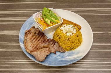 Biftek, jambon, yumurta ve erimiş peynirli, yanında da kızarmış patates ve ev yapımı golf sosu olan bir Mostrito.