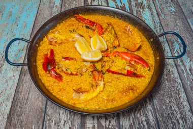 Garnitür olarak kabuklu ıstakoz paella, tavadan masaya servis edilir.