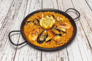 Karışık paella deniz ürünleri ve etin karışımı, mükemmel pişirilmiş bomba pilavı çorbanın tüm lezzetlerini emdi.