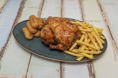 Kızarmış tavuğun yanında patates kızartması da var. Meyve sularının servis edildiğinde patatesleri nasıl hafifçe yağladığını gösteriyor.